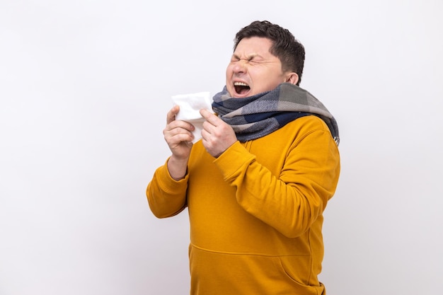 Hombre estornudando en la limpieza de servilletas moqueando la nariz y tosiendo síntomas de influenza