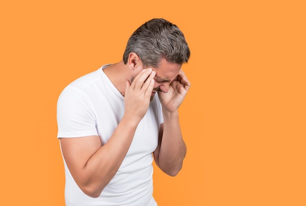 Hombre estresado con migraña en foto de estudio de hombre caucásico estresado con camisa de desgaste de migraña