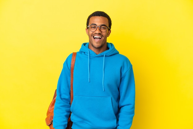 Hombre estudiante afroamericano sobre fondo amarillo aislado con expresión facial sorpresa