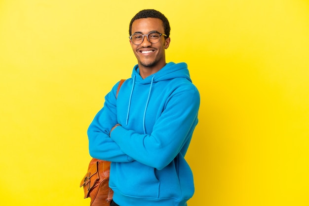 Hombre estudiante afroamericano sobre fondo amarillo aislado con gafas y sonriendo