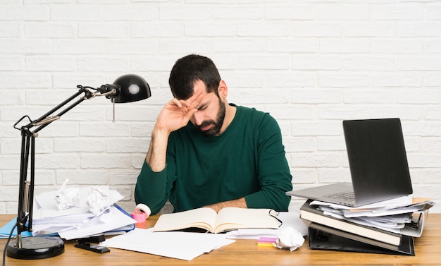 Hombre estudiante con expresión cansada y enferma.