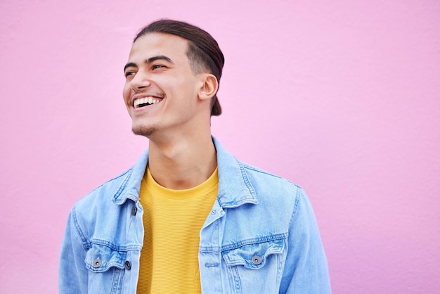 Foto hombre estudiante feliz y de moda por antecedentes con motivación de sonrisa o estilo de vida con visión chico joven de la generación z emocionado y sueña para el futuro con metas felicidad y ropa vanguardista por la pared rosa en la ciudad