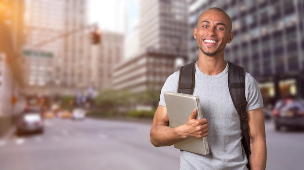 Hombre estudiante con laptop sonriendo a la cámara