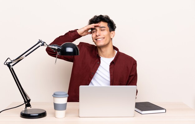 Hombre estudiante en un lugar de trabajo con una computadora portátil