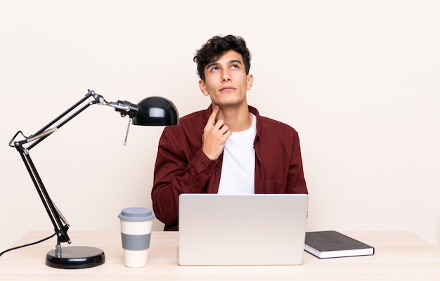 Hombre estudiante en un lugar de trabajo con una computadora portátil