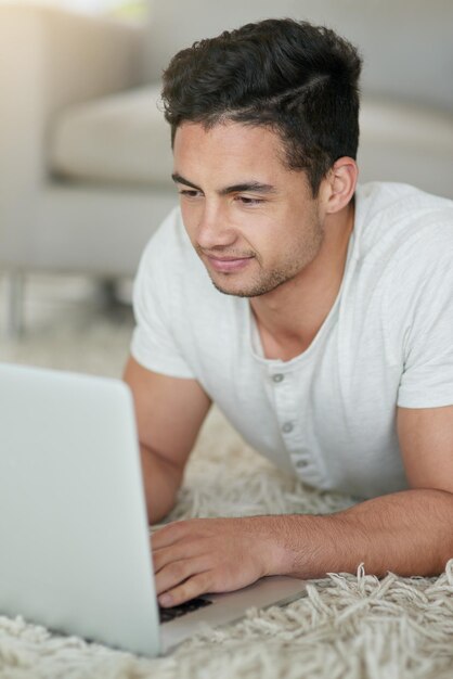 Hombre y estudiante portátil para la educación en el piso de casa y navegar para la investigación en el proyecto de la universidad Hombre persona salón y sitio web de la universidad para la asignación de cursos y aplicación para el estudio o clase en línea