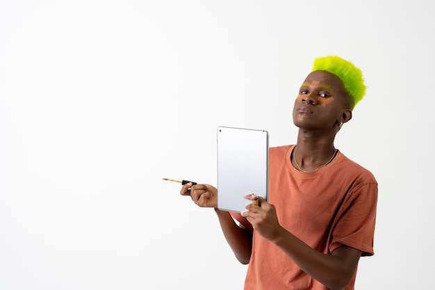 Un hombre de etnia negra gay maquillando el retrato del concepto LGTBI corrigiendo las ojeras con un espejo