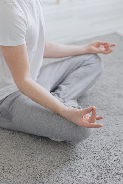 Un hombre europeo medita en su espacioso y acogedor apartamento haciendo deporte o yoga