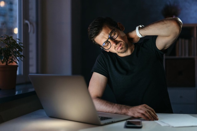 El hombre con exceso de trabajo siente dolor en el cuello