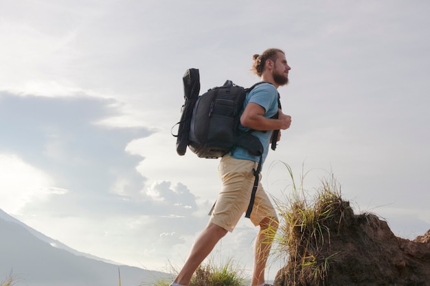 Hombre excursionista con mochila de viaje en la cima del volcán Batur, Indonesia