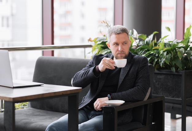 Hombre exitoso adulto en café bebiendo café