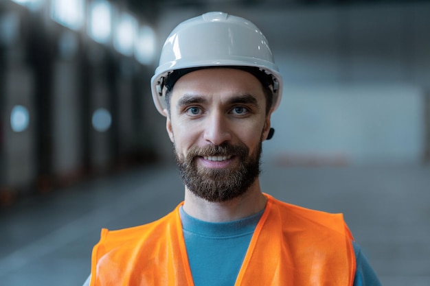 Foto hombre exitoso, confiado, trabajador, capataz con sombrero blanco, mirando a la cámara.