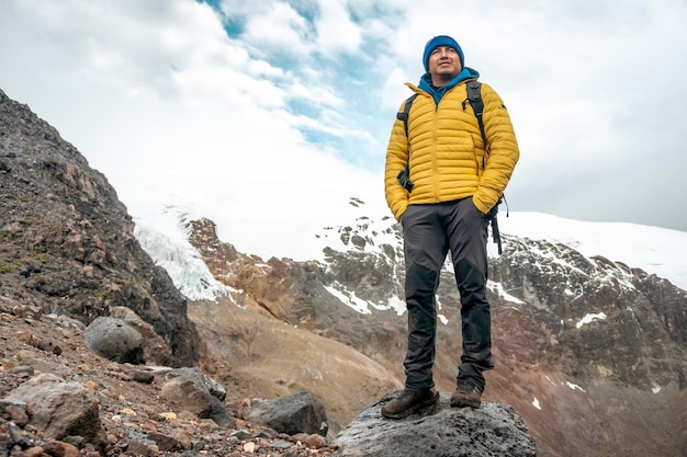 Hombre exitoso mochilero senderismo en las montañas de invierno