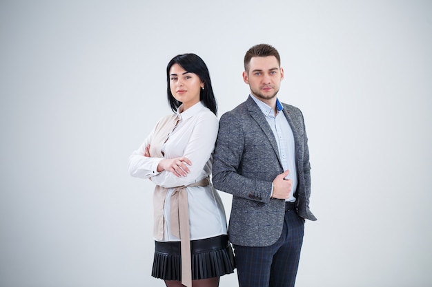 Hombre exitoso en un traje y una mujer futuros empresarios están sonriendo y hablando de un nuevo proyecto. Socios comerciales están parados sobre un fondo blanco.