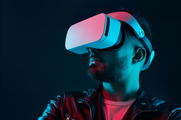 Hombre explorando realidad virtual en gafas en cuarto oscuro