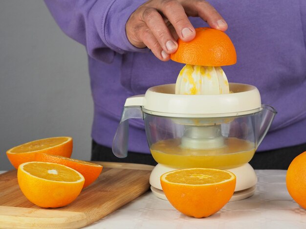 Foto un hombre exprime jugo de naranja