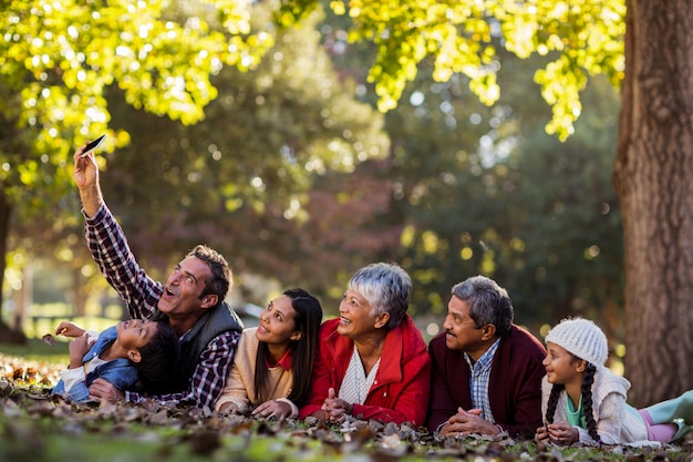 Hombre con familia tomando selfie en el parque