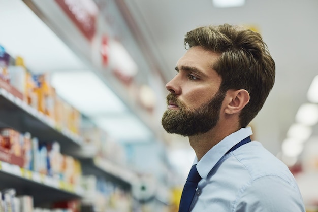 Hombre farmacia y búsqueda de estantes para medicamentos cliente y en busca de antibióticos en la farmacia hombre atención médica y pasillo para medicamentos compras consumidor y farmacéutico para pastillas o pastillas