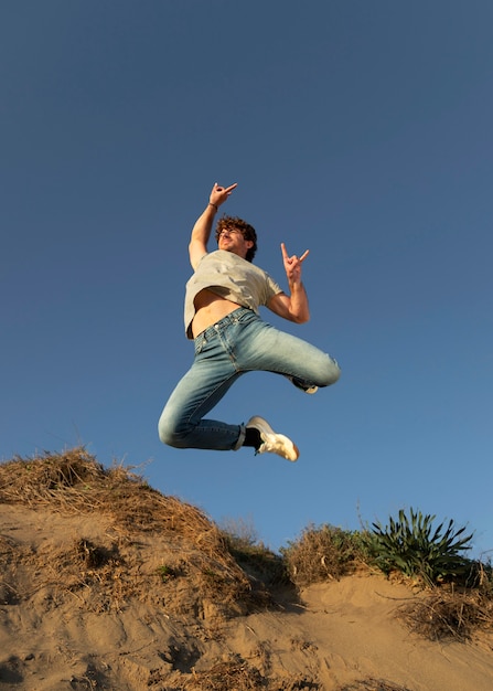 Foto hombre feliz al aire libre saltando