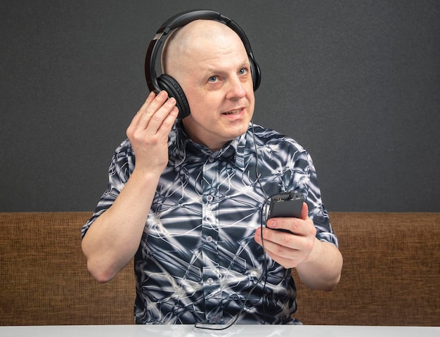 Hombre feliz con auriculares portátiles escucha música con un reproductor