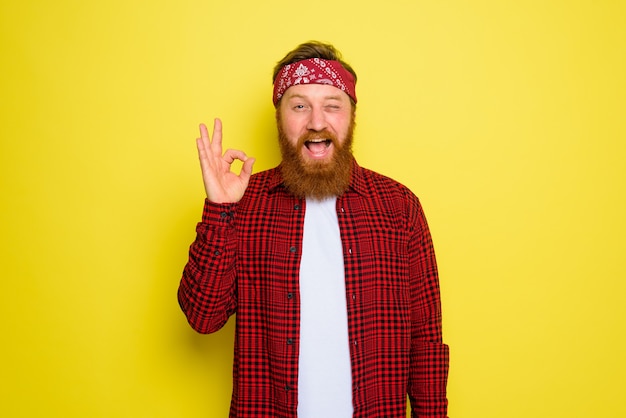 Hombre feliz con barba y pañuelo en la cabeza.