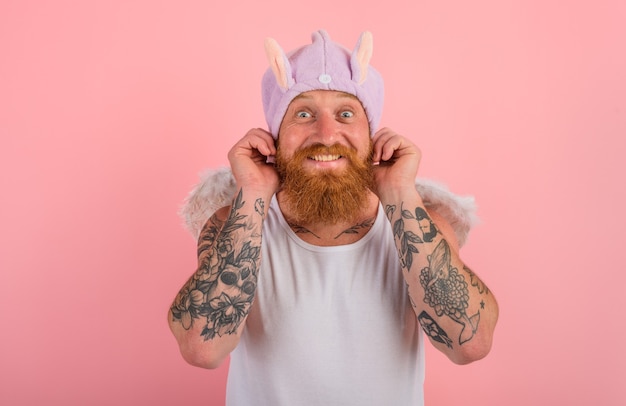 Hombre feliz con barba y tatuajes actúa como un ángel