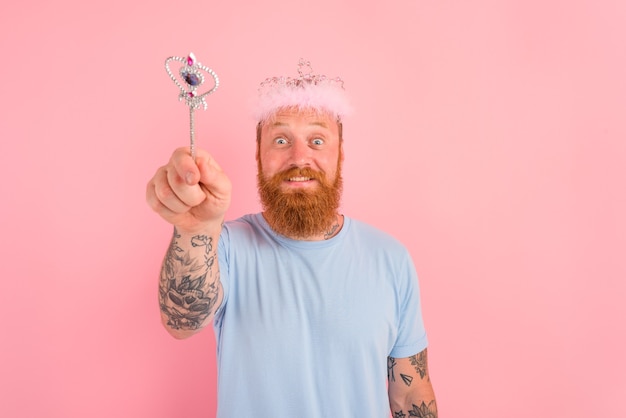 Hombre feliz con barba y tatuajes actúa como una princesa de cuento