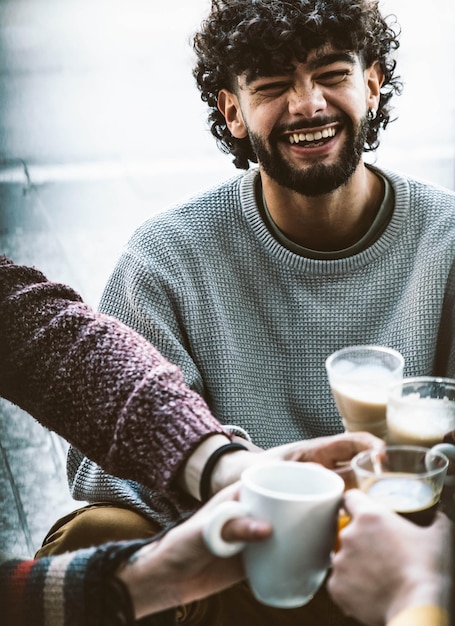 Hombre feliz bebiendo capuchino en el bar cafetería