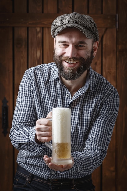 Hombre feliz bebiendo cerveza de la taza