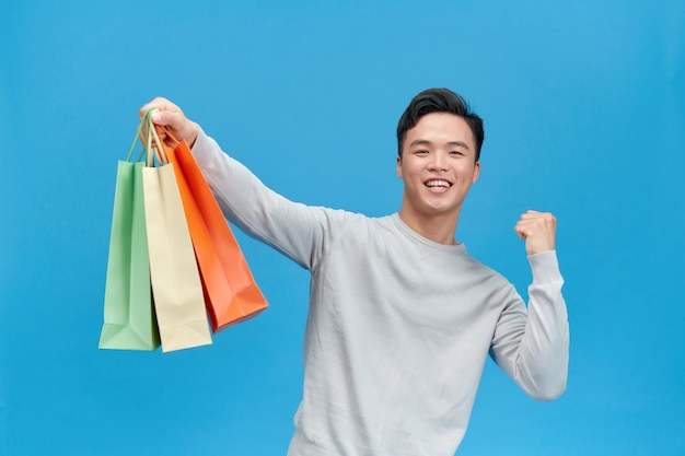 Hombre feliz con bolsas gesticulando con las manos