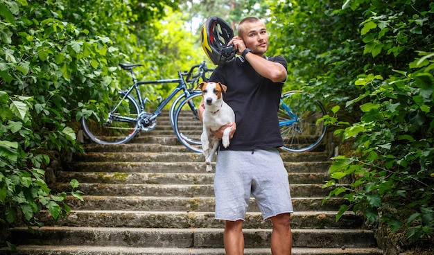 Hombre feliz en el bosque con su pequeño perro.