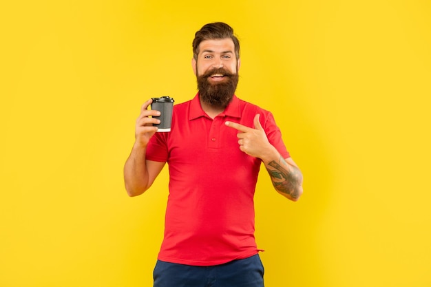 Hombre feliz en camiseta roja casual señalando con el dedo a la taza desechable papercup café barista