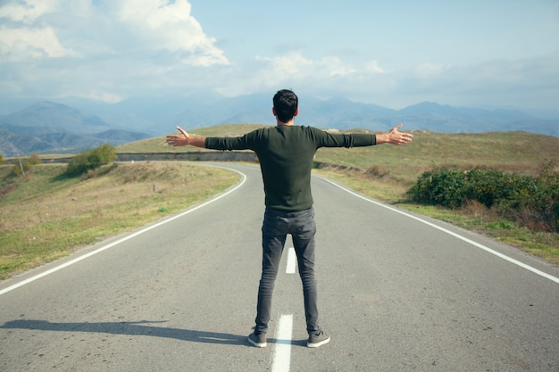 Foto hombre feliz en la carretera de asfalto vacía