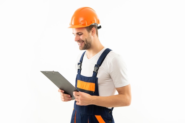 Hombre feliz con casco protector tomando notas hombre con casco sostiene documentos de construcción del proyecto firmando un contrato ingeniero tiene experiencia en trabajo de seguridad del portapapeles