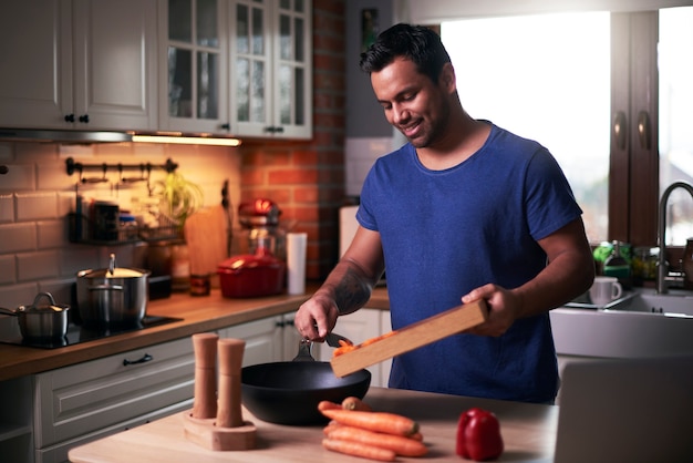 Foto hombre feliz cocinando en la cocina