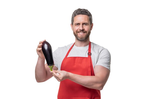 Hombre feliz en delantal con vegetales de berenjena aislado en blanco