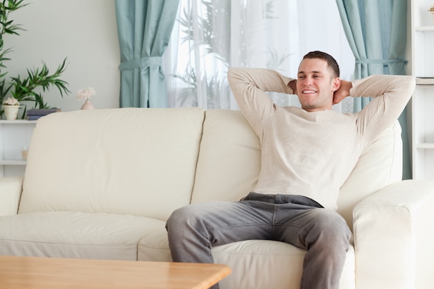 Hombre feliz descansando en un sofá