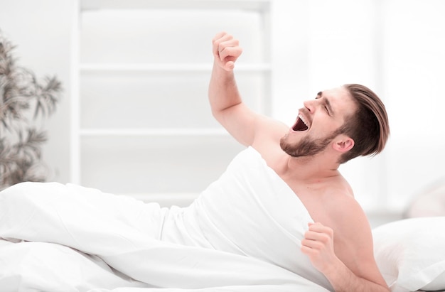 Hombre feliz despertando en una habitación cómoda