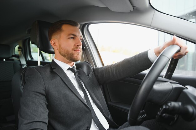 Hombre feliz elegante atractivo en buen coche