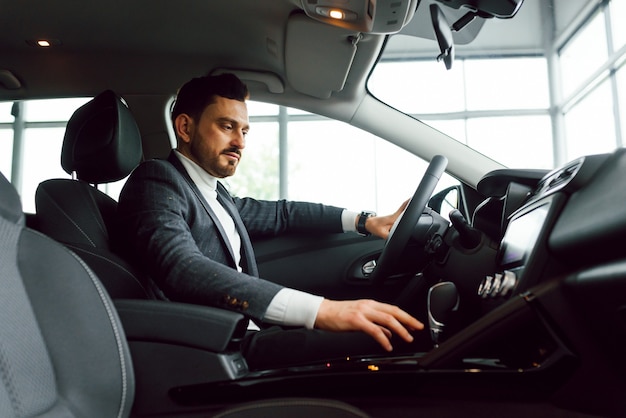 Hombre feliz elegante atractivo en buen coche