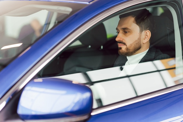 Hombre feliz elegante atractivo en buen coche