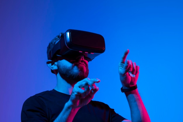 Hombre feliz y emocionado jugando a un videojuego de carreras con auriculares de realidad virtual en un mundo metaverso con un amigo Persona conceptual de tecnología futura