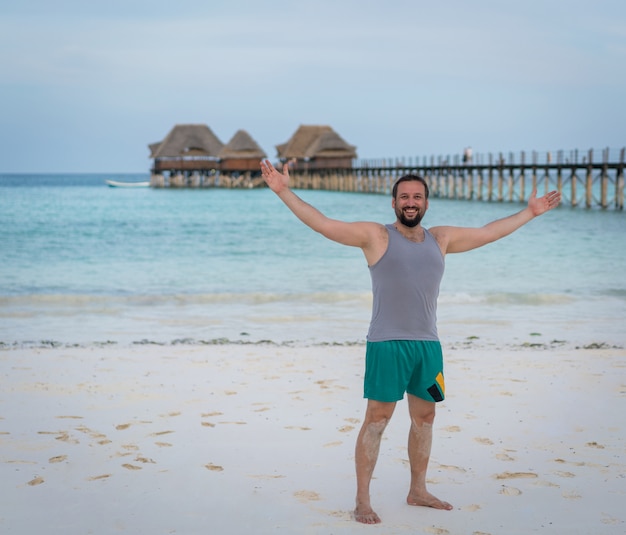 Hombre feliz emocionado en playa tropical