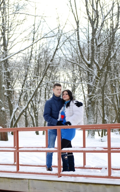 Hombre feliz enamorado de su mujer embarazada afuera en un paisaje de invierno. pareja embarazada en el parque de invierno