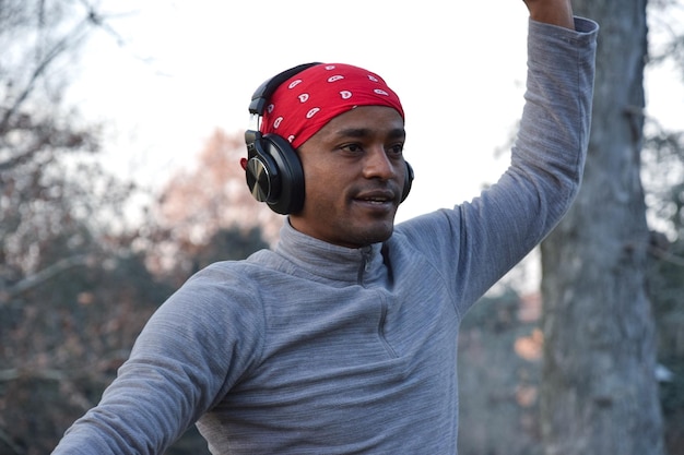 Hombre feliz entrenando en el parque con auriculares