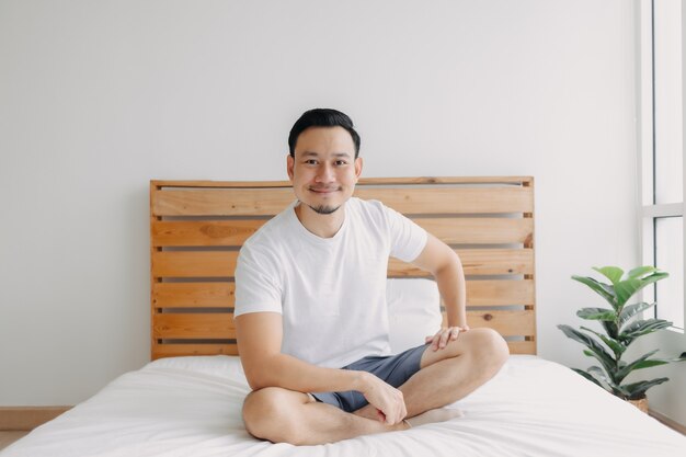 Hombre feliz escalofriante y relajado en su concepto de cama de una mente sana