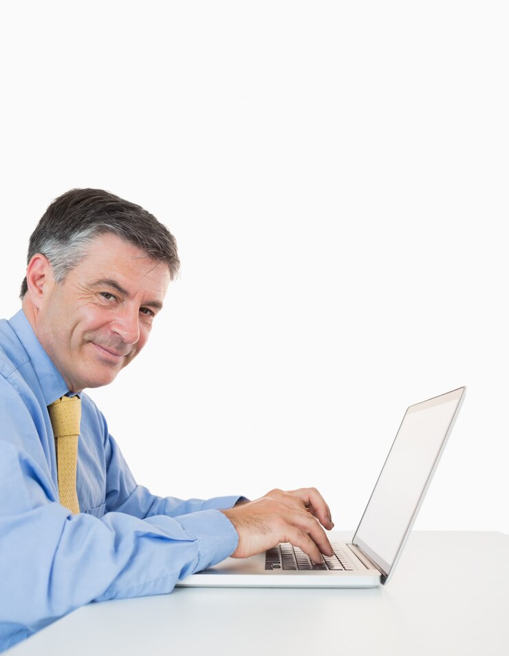 Foto hombre feliz escribiendo en una computadora portátil en el escritorio