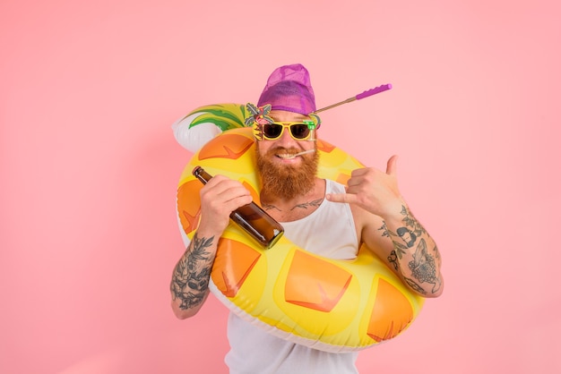 Hombre feliz está listo para nadar con un salvavidas de rosquilla con cerveza y cigarrillos