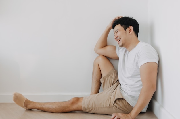 El hombre feliz está sentado en la esquina de la habitación