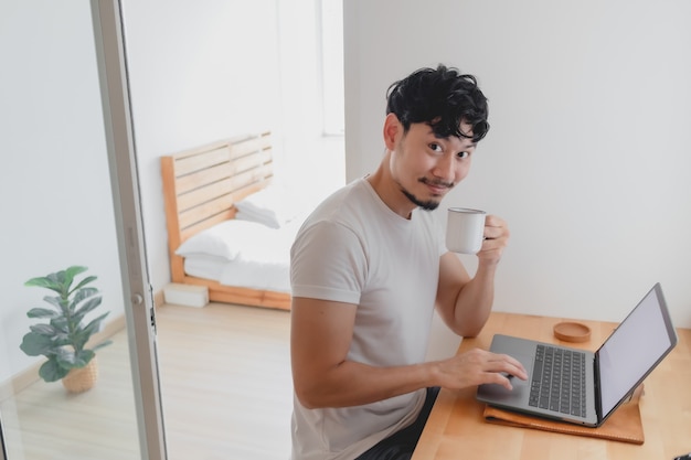 Hombre feliz está trabajando en su concepto de apartamento de trabajo desde casa